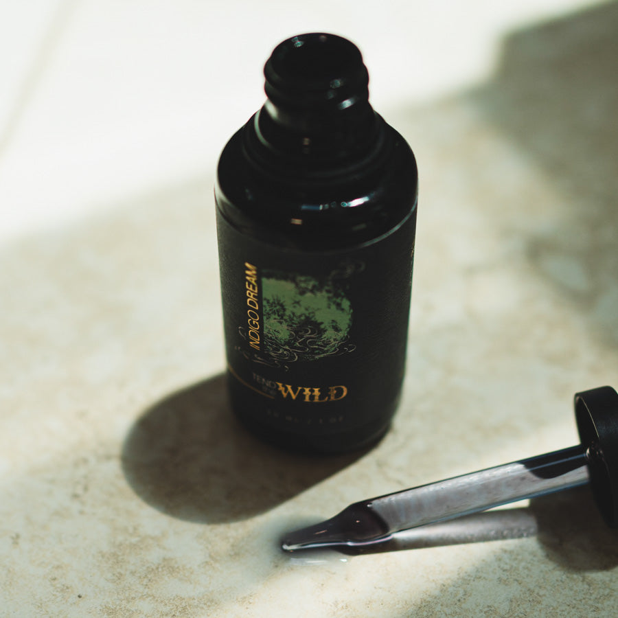 Black bottle with dropper on a light surface